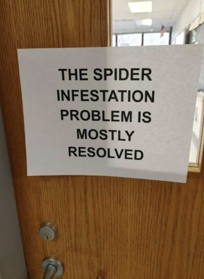 Door sign saying "The spider infestation problem is mostly resolved"
