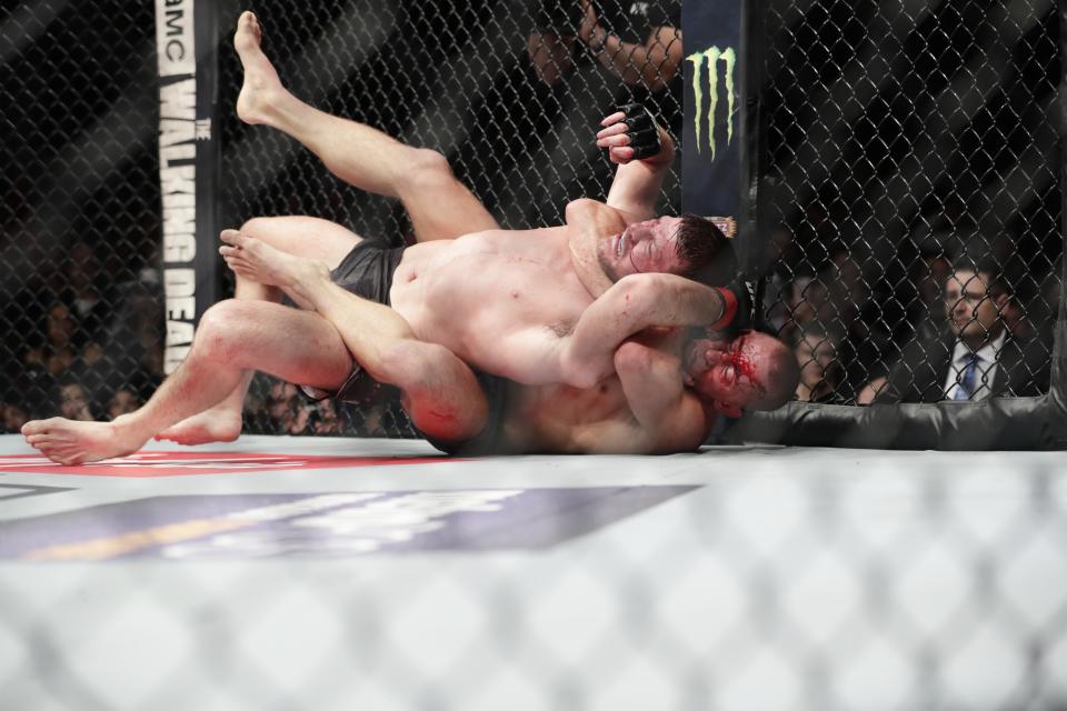 Georges St-Pierre, below, of Canada, fights England’s Michael Bisping during a middleweight title mixed martial arts bout at UFC 217 early Sunday, Nov. 5, 2017, in New York. St-Pierre won the fight. (AP Photo/Frank Franklin II)