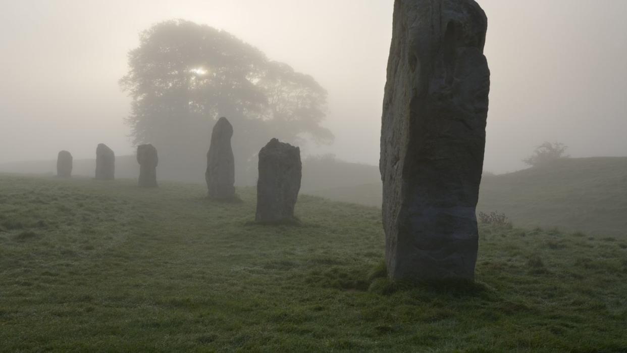 neolithic stone circle in fog at avebury, 