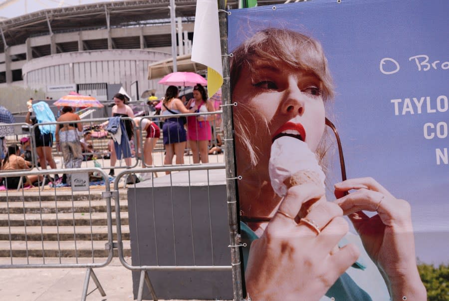 Taylor Swift fans wait for the doors of Nilton Santos Olympic stadium to open for her Eras Tour concert amid a heat wave in Rio de Janeiro, Brazil, Saturday, Nov. 18, 2023. A 23-year-old Taylor Swift fan died at the singer’s Eras Tour concert in Rio de Janeiro Friday night, according to a statement from the show’s organizers in Brazil. (AP Photo/Silvia Izquierdo)