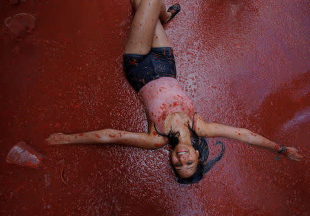 A reveller plays with tomato pulp during the annual "Tomatina" festival in Bunol, near Valencia, Spain, August 29, 2018. REUTERS/Heino Kalis