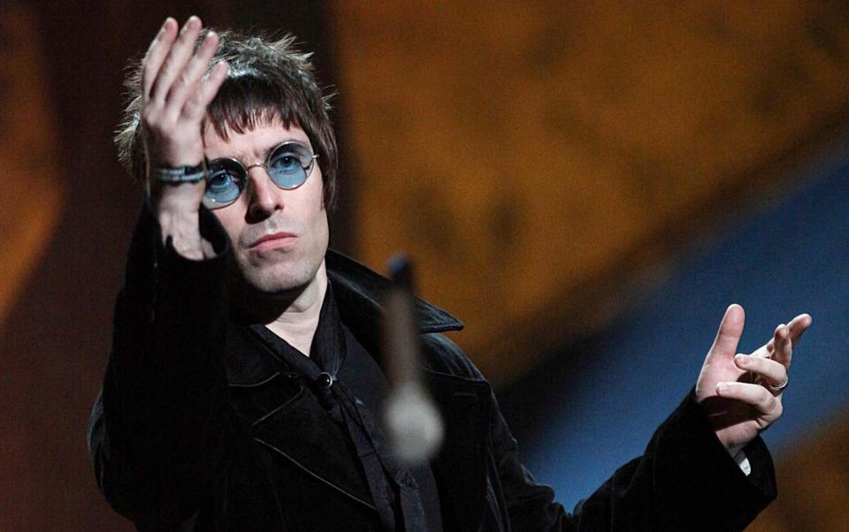 Liam Gallagher throws his microphone into the crowd as he collects his award, 2010