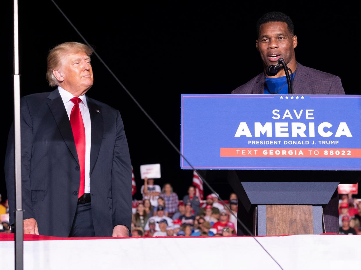 Former President Donald Trump listens as Georgia Senate candidate Herschel Walker speaks during his Save America rally in Perry, Ga., on Saturday, Sept. 25, 2021.