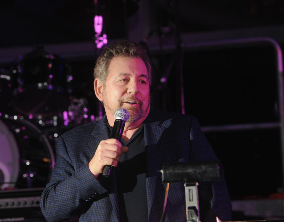 James Dolan in a suit jacket with a microphone at an event. 