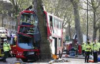 Members of the emergency services attend to a bus which crashed into a tree in Kennington, south London, December 20, 2013. 23 people were injured, two seriously, in the crash according to the Metropolitan Police. REUTERS/Suzanne Plunkett (BRITAIN - Tags: DISASTER TRANSPORT)