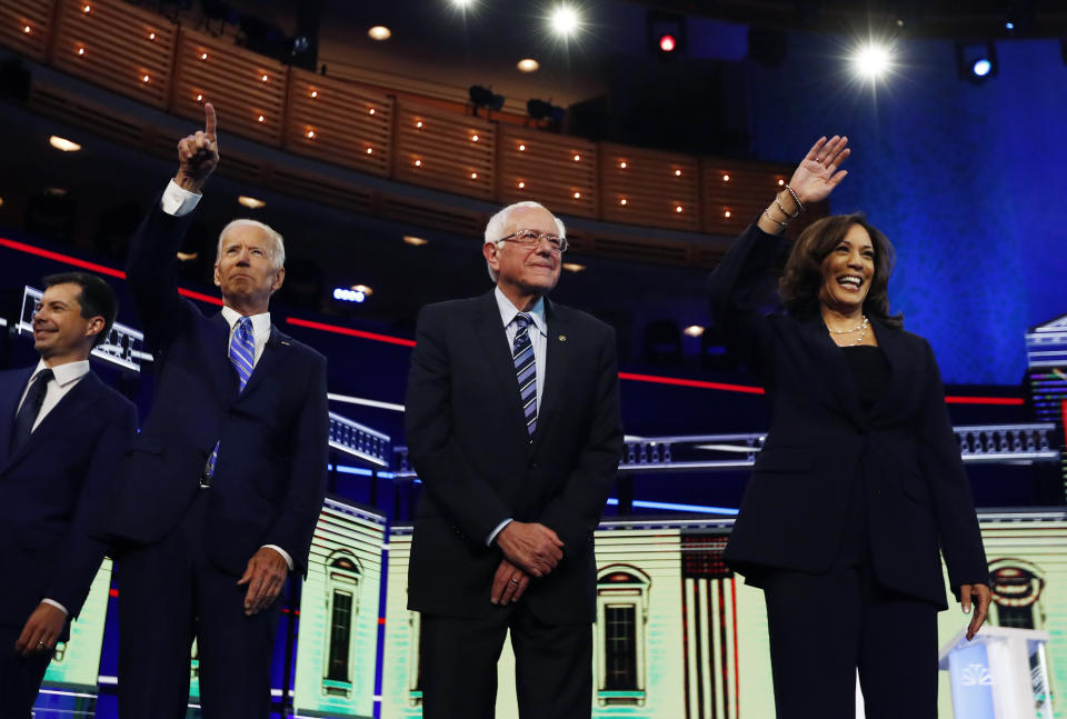 Democratic presidential candidates from left, South Bend Mayor Pete Buttigieg, former vice president Joe Biden, Sen. Bernie Sanders, I-Vt., and Sen. Kamala Harris, D-Calif., gesture before the start of the Democratic primary debate hosted by NBC News at the Adrienne Arsht Center for the Performing Arts, Thursday, June 27, 2019, in Miami. (AP Photo/Brynn Anderson)