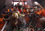 Indian Hindu Kanwarias, worshippers of the Hindu God Shiva, offer holy water from the Ganges River at Padilla Mahadev temple, on the outskirts of Prayagraj, India, Sunday, Sept. 27, 2020. Kanwarias are devotees performing a ritual pilgrimage in which they walk the roads of India, clad in saffron, and carry ornately decorated canisters of the sacred water from the Ganges River to take back to Hindu temples in their hometowns. (AP Photo/Rajesh Kumar Singh)