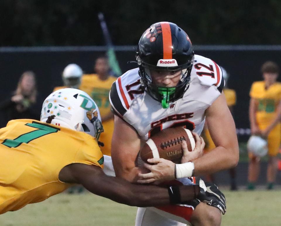 Spruce Creek High's Luke Smith #12 on a QB keeper as DeLand High's Rameir Gordon #7 goes for the tackle, Friday September 29, 2023 in Port Orange.