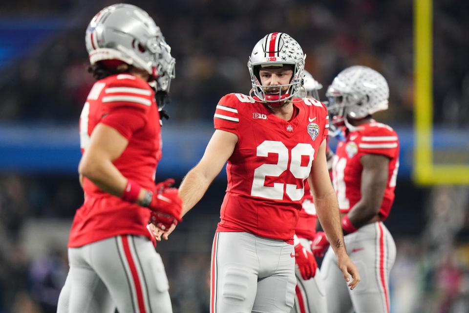 Dec 29, 2023; Arlington, Texas, USA; Ohio State Buckeyes punter Jesse Mirco (29) high fives teammates after a punt during the Goodyear Cotton Bowl Classic at AT&T Stadium. Ohio State lost 14-3.