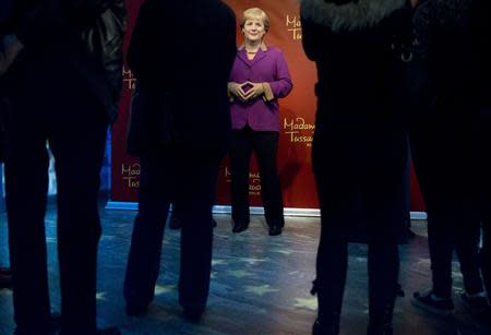 Tourists surround the wax figure of German Chancellor Angela Merkel at the Madame Tussauds wax museum in Berlin, September 19, 2013. REUTERS/Thomas Peter