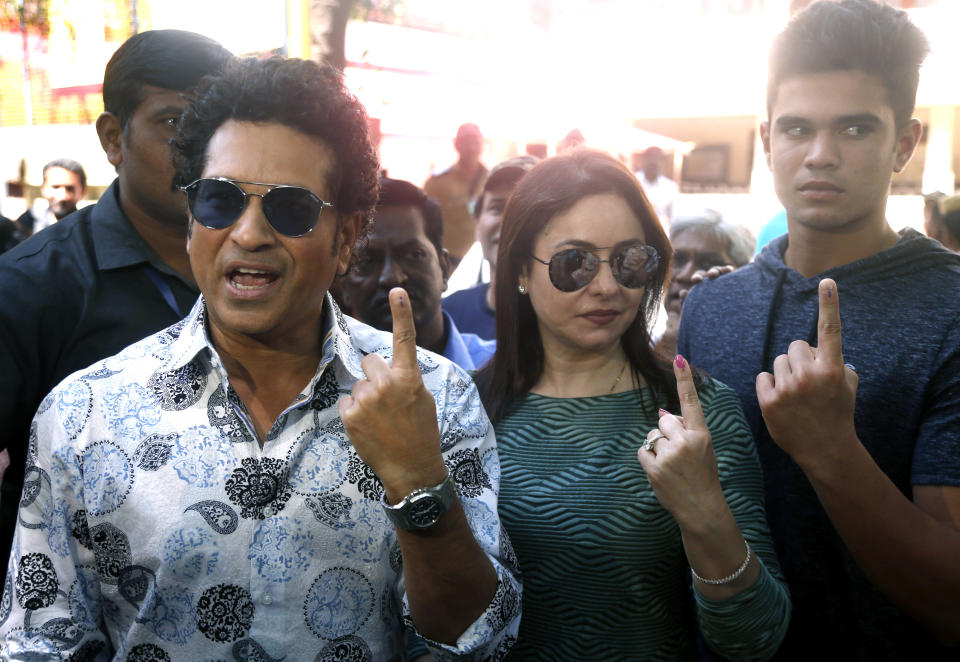 Former Indian cricketer Sachin Tendulkar, left, with his wife Anjali and son Arjun pose for media after casting their votes in Mumbai, India, Monday, Oct. 21, 2019. Voting is underway in two Indian states of Maharashtra in the west and Haryana in the north where the Hindu nationalist Bharatiya Janata Party (BJP) headed by prime minister Narendra Modi is trying to win a second consecutive term. (AP Photo/Rafiq Maqbool)