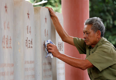 Vietnamese veteran Duong Van Dau cleans the headstones of North Korean pilots at the memorial site for North Korean pilots who fought and died during Vietnam War, in Bac Giang province, Vietnam February 13, 2019. REUTERS/Kham