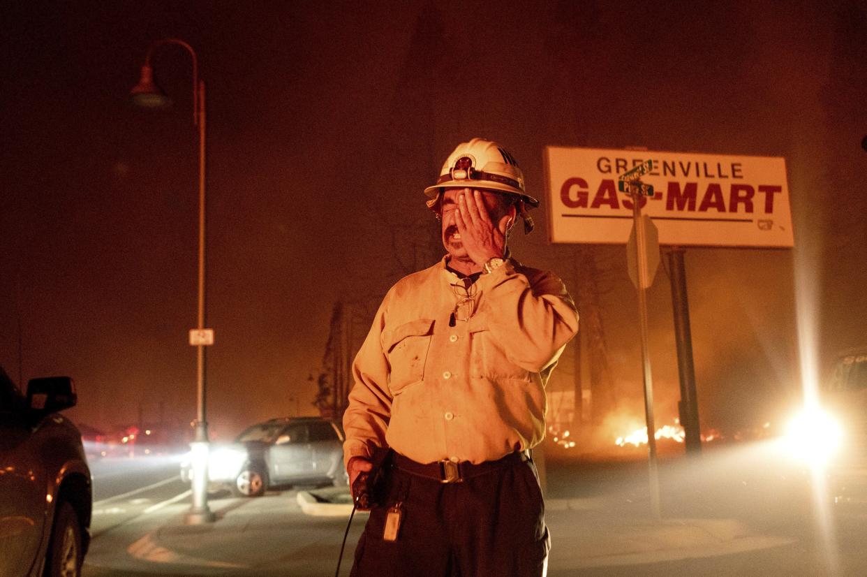 Battalion Chief Sergio Mora rubs his face as the Dixie Fire tears through the Greenville community of Plumas County, Calif. on Wednesday, Aug. 4, 2021. The fire leveled multiple historic buildings and dozens of homes in central Greenville.