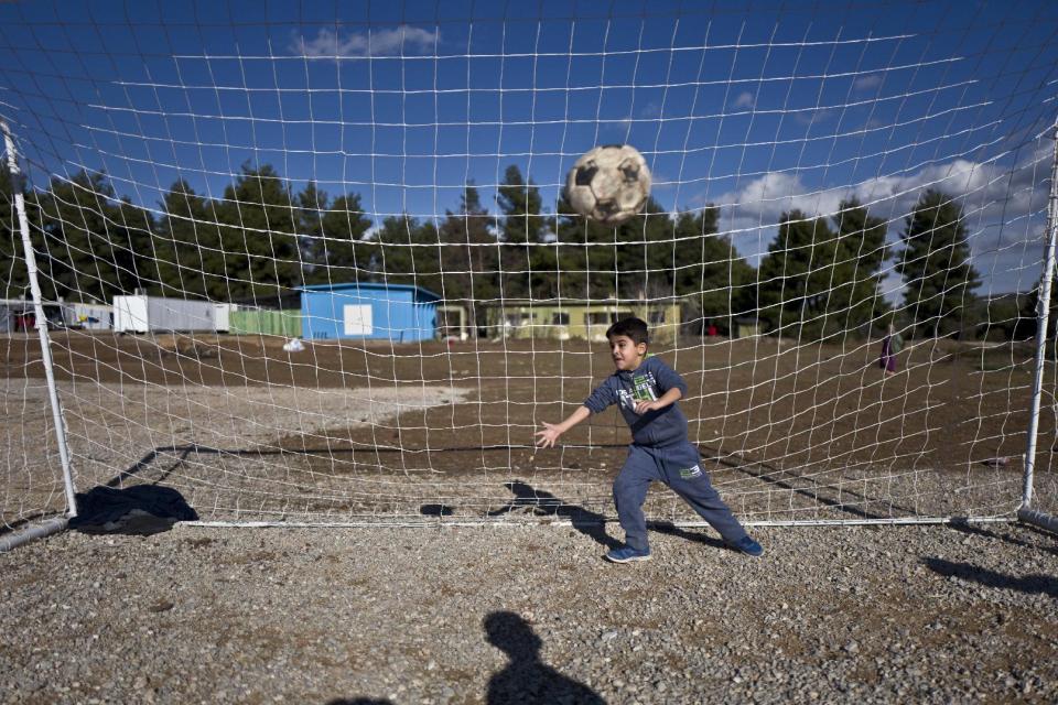 A Syrian refugee boy tries to catch the ball while he and others play soccer at the Ritsona refugee camp, about 86 kilometers (53 miles) north of Athens, Thursday, Jan. 5, 2017. Over 62,000 refugees and migrants are stranded in Greece after a series of Balkan border closures and an European Union deal with Turkey to stop migrant flows. (AP Photo/Muhammed Muheisen)