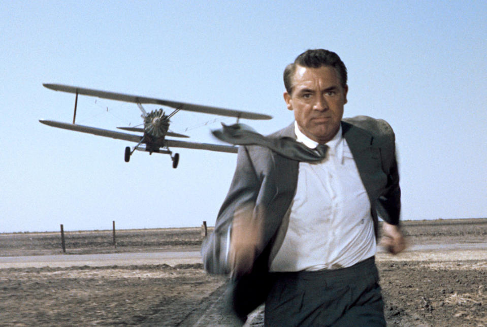 Cary Grant in North By Northwest in a grey suit running through a field chased by a plane