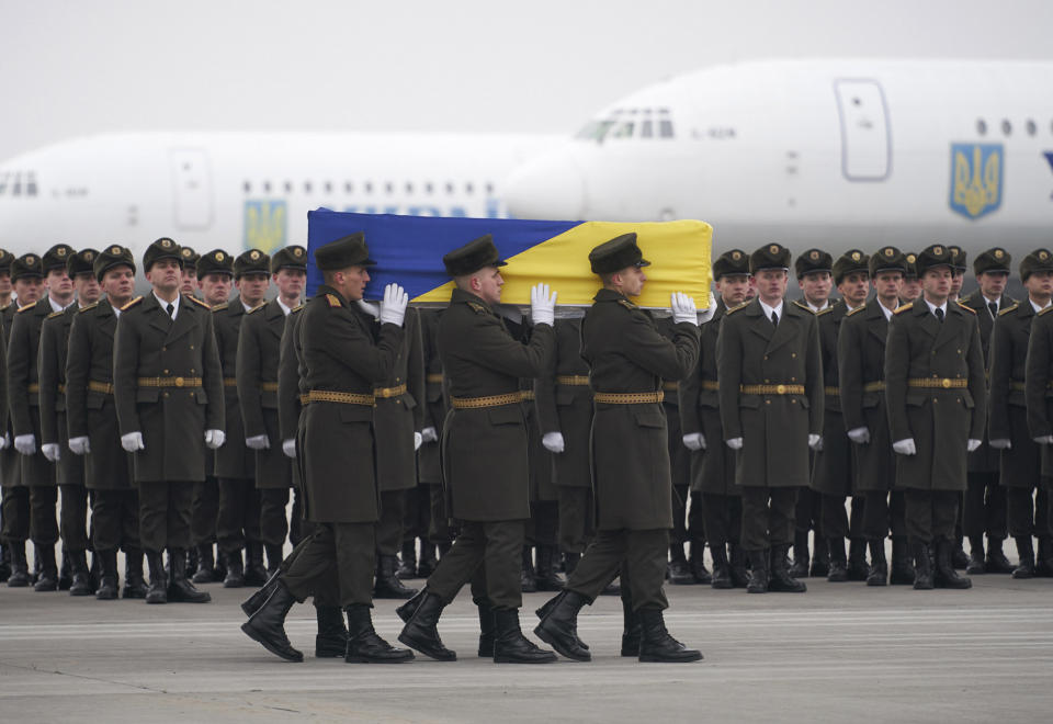 In this photo provided by the Ukrainian Presidential Press Office, honor guards carry a coffin of the one of the eleven Ukrainian victims of the Ukrainian 737-800 plane that crashed on the outskirts of Tehran, during a memorial ceremony at Borispil international airport outside Kyiv, Ukraine, Sunday, Jan. 19, 2020. An Ukrainian passenger jet carrying 176 people has crashed just minutes after taking off from the Iranian capital's main airport on Jan. 8, 2020. (Ukrainian Presidential Press Office via AP)