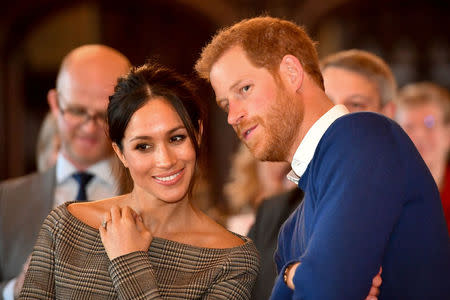 File Photo: Britain's Prince Harry whispers to Meghan Markle as they watch a dance performance by Jukebox Collective in the banqueting hall during a visit to Cardiff Castle in Cardiff, Britain, January 18, 2018. REUTERS/Ben Birchall/Pool