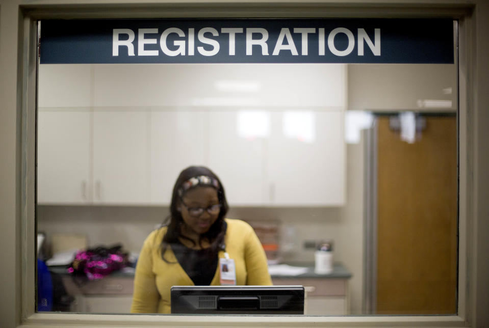 In this Friday, Jan. 24, 2014 photo, a worker is seen behind the registration window of the emergency room at Grady Memorial Hospital, in Atlanta. In two years, federal payments to hospitals treating a large share of the nation’s poor will begin to evaporate under the premise that more people than ever will have some form of insurance under the federal health care law. The problem is that many states have refused to expand Medicaid, leaving public safety net hospitals there in a potentially precarious financial situation and elected officials facing growing pressure to find a fiscal fix. And in an election year, Democrats are using the decision by Republican governors not to expand Medicaid as a major campaign issue and arguing the hospital situation could have been avoided. (AP Photo/David Goldman)