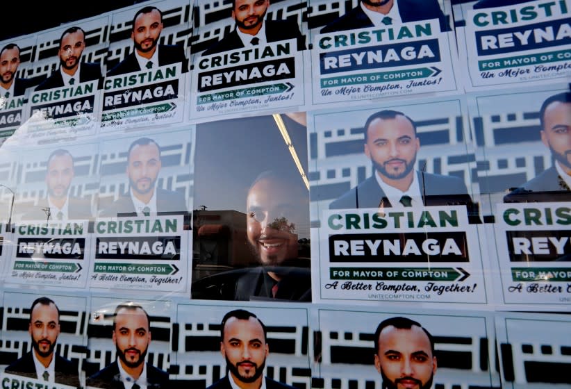 COMPTON, CA - MAY 12:. Compton mayoral candidate Cristian Reynaga is framed by campaign flyers hanging in the window of his campaign's headquarters on Wednesday, May 12, 2021. A native of Compton, Reynaga works in the real estate business. (Luis Sinco / Los Angeles Times)