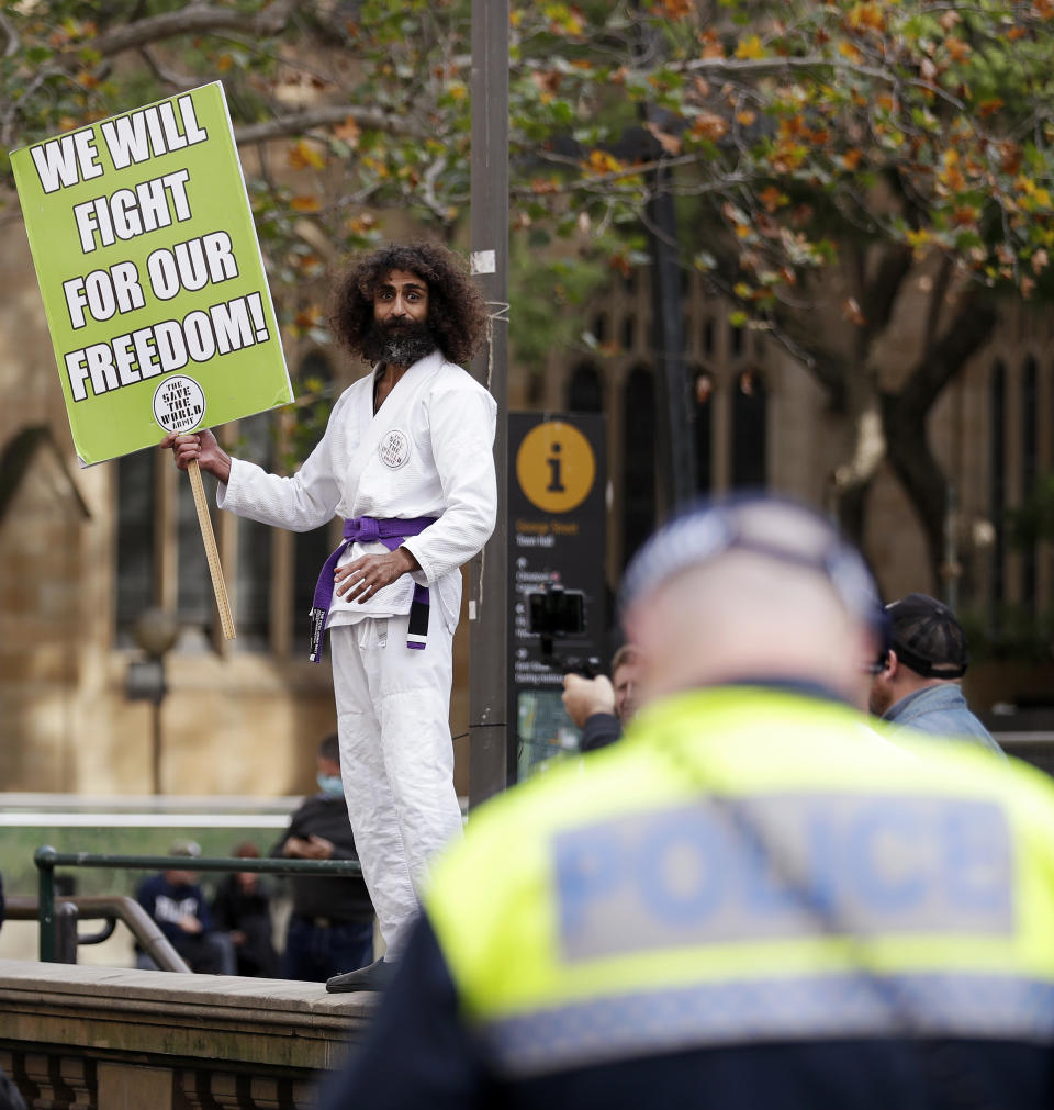 A man dressed in a martial arts uniform addresses supporters as protesters gather in Sydney, Saturday, June 13, 2020, during a day of demonstrations across Australia in support of the Black Lives Matter movement and refugee rights. Protesters in Sydney, Adelaide and Perth were urged to stay away by government officials concerned about the risk of spreading the new coronavirus. (AP Photo/Rick Rycroft)