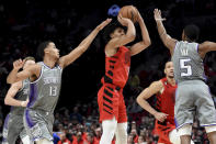 Portland Trail Blazers guard Shaedon Sharpe, center, shoots the ball over Sacramento Kings forward Keegan Murray, left, and guard De'Aaron Fox, right, during the second half of an NBA basketball game in Portland, Ore., Wednesday, March 29, 2023. The Kings won 120-80. (AP Photo/Steve Dykes)