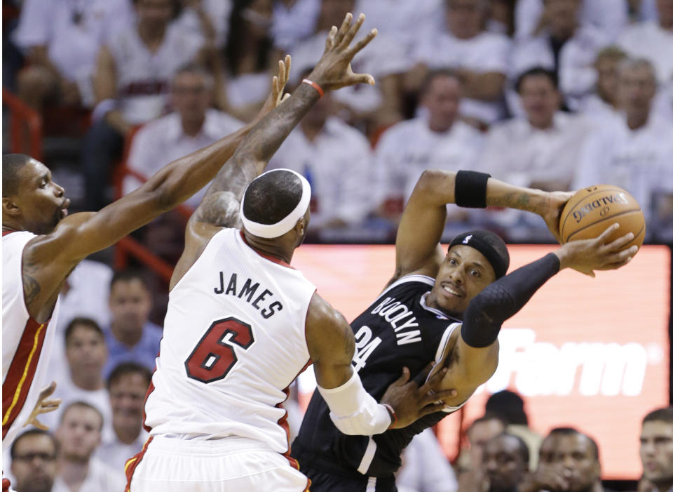 Brooklyn Nets forward Paul Pierce (34) looks for an open teammate past Miami Heat forward LeBron James (6) and center Chris Bosh, left, during the first half of Game 2 of an Eastern Conference semifinal basketball game, Thursday, May 8, 2014 in Miami. (AP Photo/Wilfredo Lee)