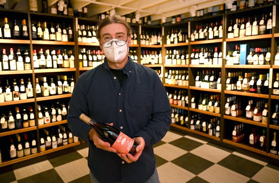 Richard Schnitzlein, owner of Fiske & Main Specialty Wine and Cheese in Upton,  holds a bottle of Forlorn Hope 2019 "Queen of the Sierra," a red wine that is a blend of Zinfandel and other grapes, Feb. 16, 2022. 