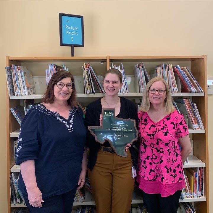Holding the Project of the Year Award they received for Candyland are, from left, Storytime specialist Melissa Burke, public services manager Gretchen Hardin and public services librarian Terry Lewis.