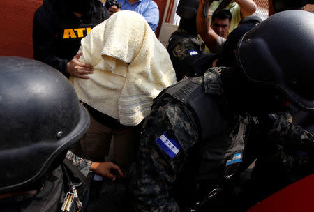 The alleged killer (C top) of environmental rights activist Berta Caceres is surrounded by members of the Military Police for Public Order (PMOP) after being detained in Tegucigalpa, Honduras, May 2, 2016. Four people were arrested in Honduras and accused of killing the environmental and indigenous rights activist Berta Caceres, the Honduran attorney general's office said in a statement on Monday. REUTERS/Jorge Cabrera