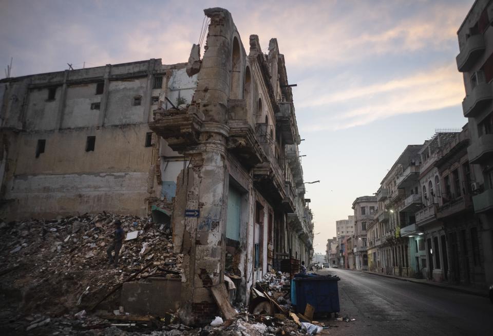 Desvencijados y derrumbados edificios en la calle San Lázaro, donde un hombre, a la izquierda, recoge ladrillos en el centro de La Habana, Cuba, el martes 10 de octubre de 2023. La crisis de la vivienda en Cuba es una de las que presenta más desafíos para la isla, dado el clima húmedo, el paso de ciclones y huracanes, el pobre mantenimiento que se le da a edificios viejos y la falta de recursos para reparaciones, que son los principales problemas y quejas de los residentes. (AP Foto/Ramón Espinosa)