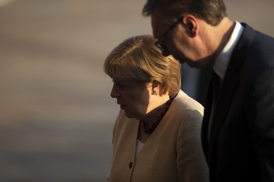 German Chancellor Angela Merkel, center, is accompanied by Serbia's president Aleksandar Vucic during her visit to Belgrade, Serbia, Monday, Sept. 13, 2021. Merkel is on a farewell tour of the Western Balkans, as she announced in 2018 that she wouldn't seek a fifth term as Germany's Chancellor. (AP Photo/Marko Drobnjakovic)