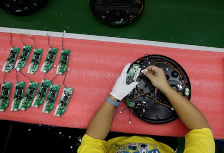 An employee works on the production line of a robot vacuum cleaner at a factory of Matsutek in Shenzhen