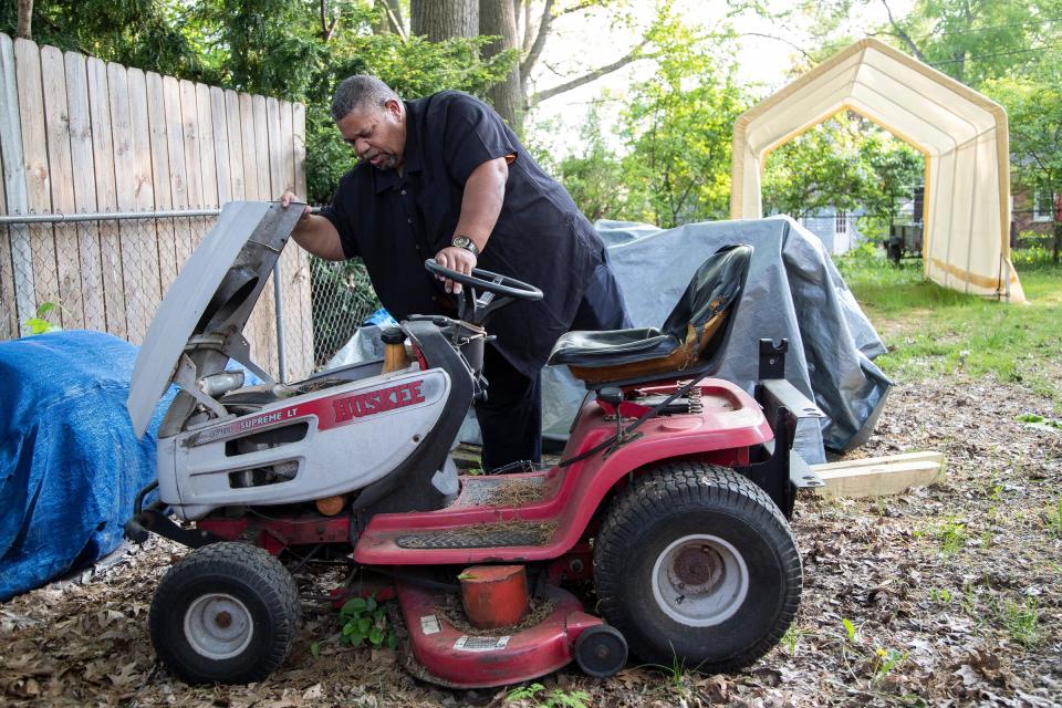 Martin Rucker, of Redford Township, Mich., tries to start his lawn mower after coming back from work at a car dealership on May 18.