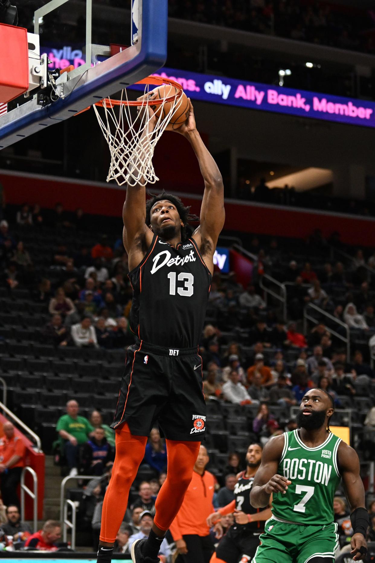 Detroit Pistons center James Wiseman (13) dunks the ball over Boston Celtics guard Jaylen Brown (7) in the first quarter at Little Caesars Arena in Detroit on Friday, March 22, 2024.