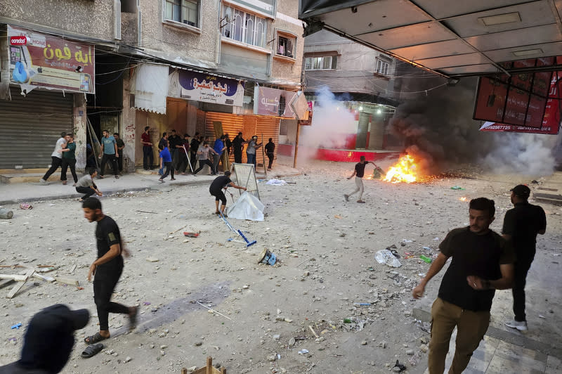 Palestinian demonstrators throw stones and burn tires