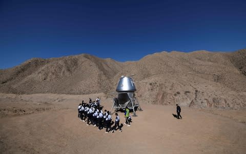 A group of students walk past a model of a lander - Credit: Wang Zhao AFP