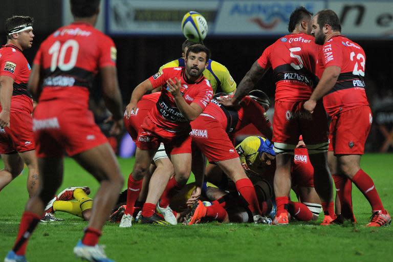 Toulon scrum-half Eric Escande (C) clears the ball during a match against Clermont on May 17, 2015 at the Marcel-Michelin stadium in Clermont-Ferrand