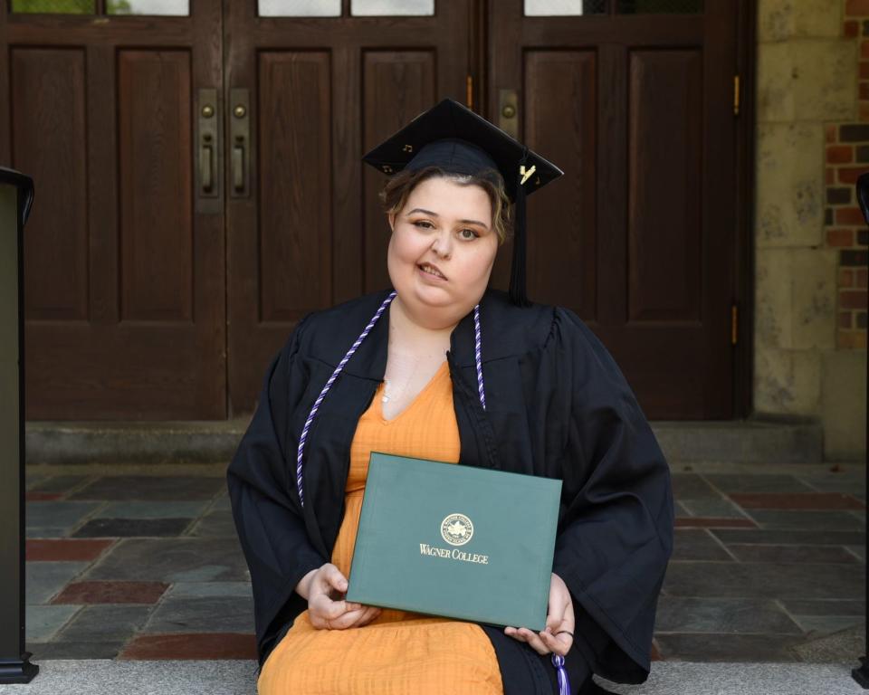 McKenzy Hupke holds up her diploma at Wagner College's graduation.