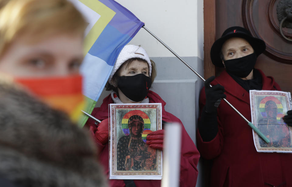 Polish LGBT rights activists gather outside a court which acquitted three women who faced trial on accusations of desecration, in Plock, Poland, Tuesday March 2, 2021. A Polish court has acquitted three activists who had been accused of desecration for adding the LGBT rainbow to images of a revered Roman Catholic icon. In posters that they put up in protest in their city of Plock, the activists used the rainbow in place of halos on a revered image of the Virgin Mary and baby Jesus. (AP Photo/Czarek Sokolowski)