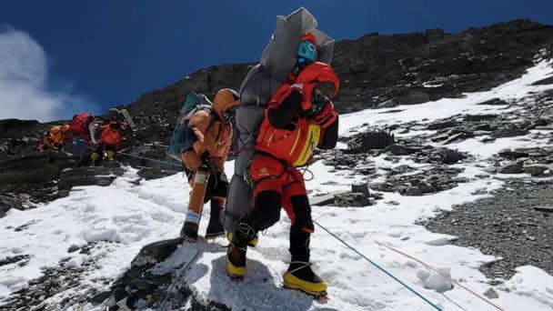 PHOTO: Ngima Tashi Sherpa walks as he carries a Malaysian climber while rescuing him from the death zone above camp four at Everest, Nepal, May 18, 2023, in this screengrab obtained from a handout video. (Gelje Sherpa via Reuters)