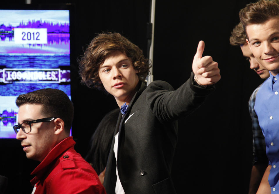 Harry Styles, of the boy band One Direction, gestures as the band poses backstage after winning awards for "Best Pop Video and "Most Share-Worthy Video" 
during the 2012 MTV Video Music Awards in Los Angeles, September 6, 2012.  REUTERS/Danny Moloshok    (UNITED STATES  - Tags: ENTERTAINMENT)    (MTV-BACKSTAGE)