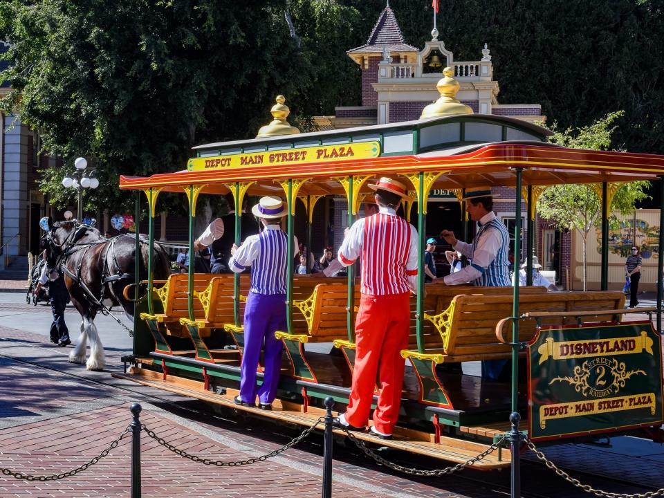 dapper dans quartet riding the main street trolley in disneyland