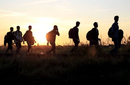 Syrian migrants walk on a railway track after crossing the Hungarian-Serbian border near Roszke, Hungary August 26, 2015. REUTERS/Bernadett Szabo