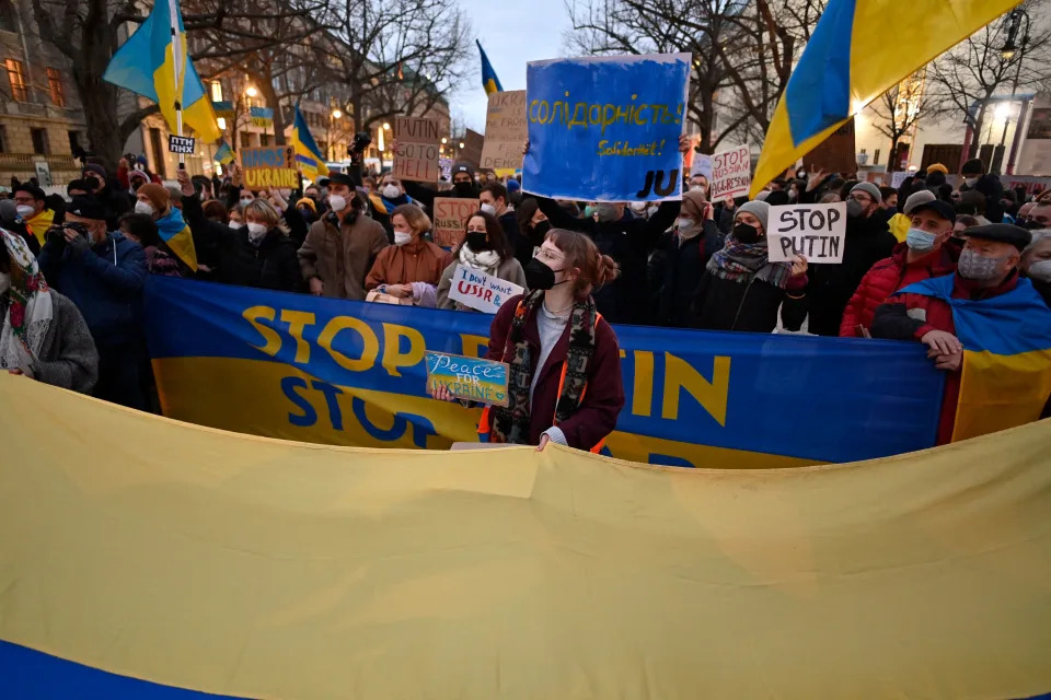 Pro-Ukraine demonstrators hold flags and placards during a demonstration in front of the Russian embassy in Berlin on February 22, 2022, following Russia's recognition of eastern Ukrainian separatists. - Russia faced a furious global diplomatic and economic backlash after President Vladimir Putin ordered his forces into Ukraine to secure two breakaway regions. (Photo by John MACDOUGALL / AFP) (Photo by JOHN MACDOUGALL/AFP via Getty Images)