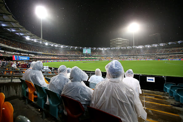 Rain falls on the crowd during AFL match at The Gabba.