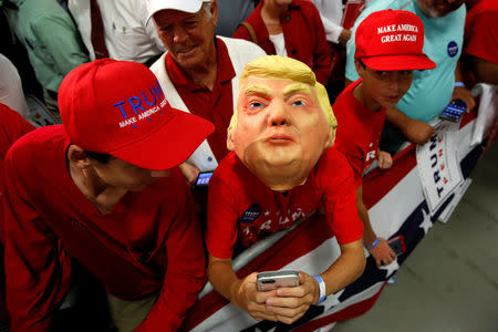 A boy wears a Trump mask as supporters rally with Republican U.S. presidential nominee Donald Trump in Fletcher, North Carolina, U.S. October 21, 2016. REUTERS/Jonathan Ernst