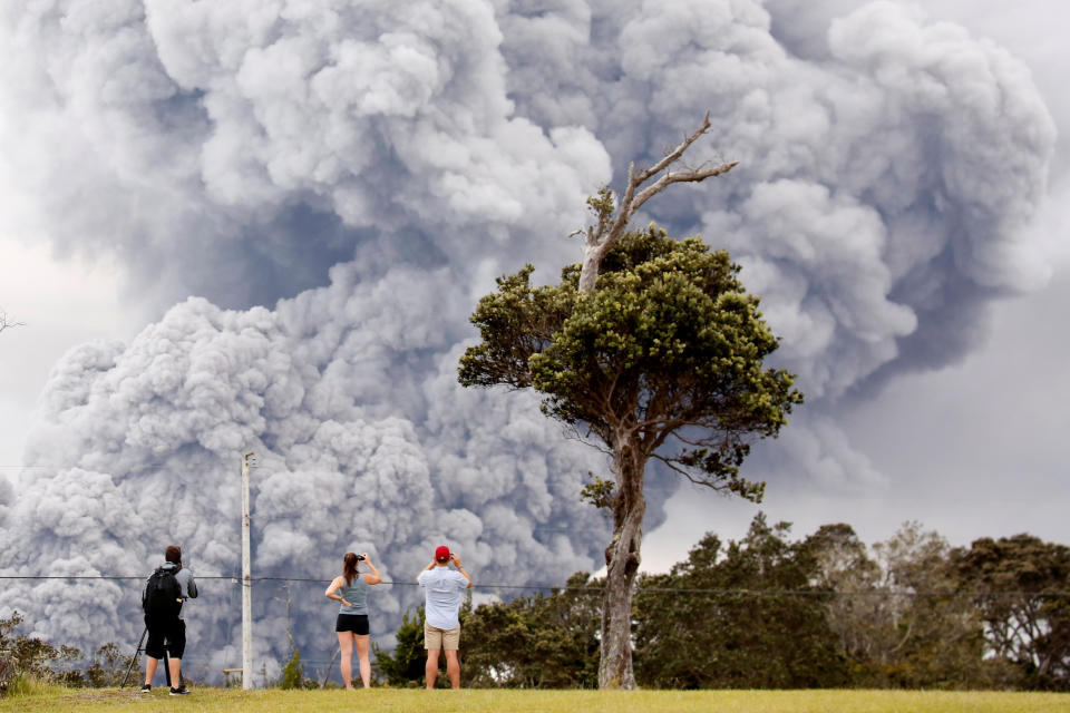 People watch as ash erupt from the Halemaumau crater near the community of Volcano during ongoing eruptions of the Kilauea Volcano in Hawaii, U.S., May 15, 2018. REUTERS/Terray Sylvester