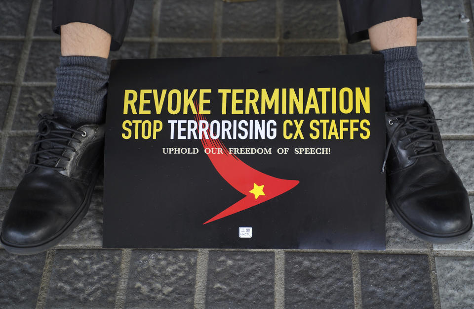 A demonstrator sits near a sign during a protest opposing the recent firings of Cathay Pacific employees in Hong Kong, Wednesday, Aug. 28, 2019. Trade union members in Hong Kong rallied Wednesday against the city's flagship Cathay Pacific airline for firing employees apparently because of links to this summer's ongoing pro-democracy protests. (AP Photo/Vincent Yu)