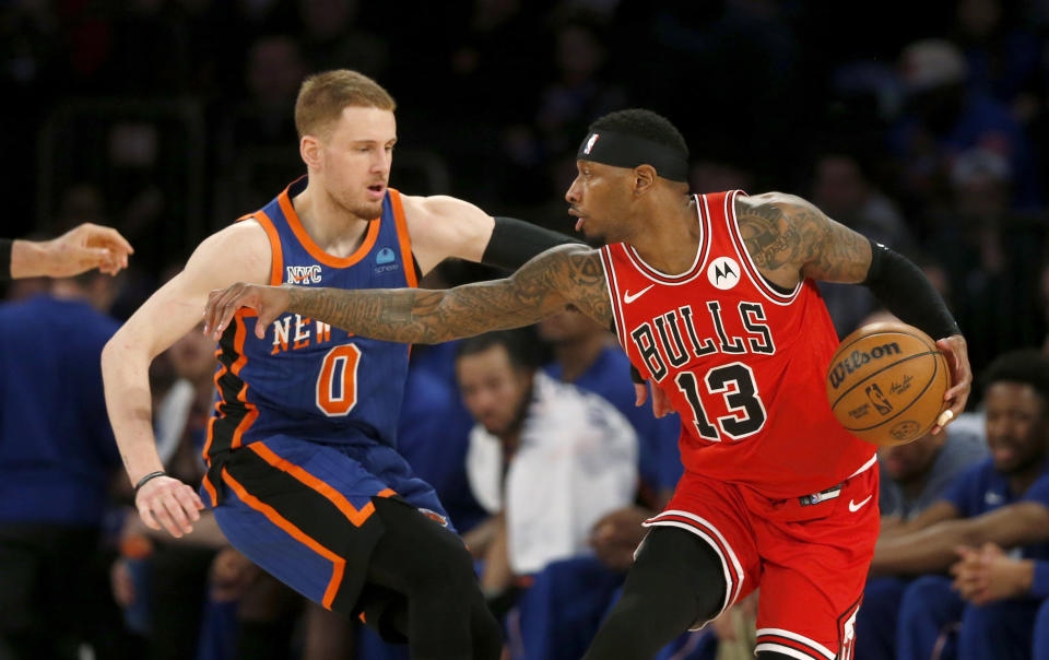 El escolta de los Knicks de Nueva York, Donte DiVincenzo (0), defiende al alero de los Bulls de Chicago, Torrey Craig (13), durante la primera mitad de un partido de baloncesto de la NBA, el domingo 14 de abril de 2024, en Nueva York. (AP Foto/John Munson)