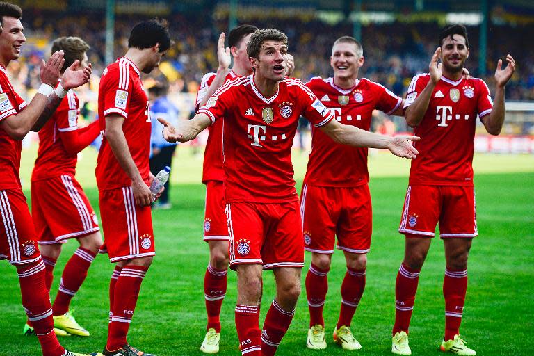 Bayern Munich's midfielder Thomas Mueller (C) celebrates with teammates after their German first division Bundesliga match against Eintracht Braunschweig, in Braunschweig, central Germany, on April 19, 2014